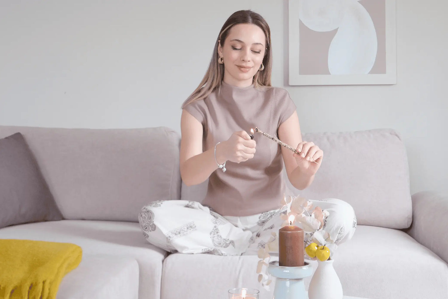 Woman sitting comfortable on her modular couch lighting her incense